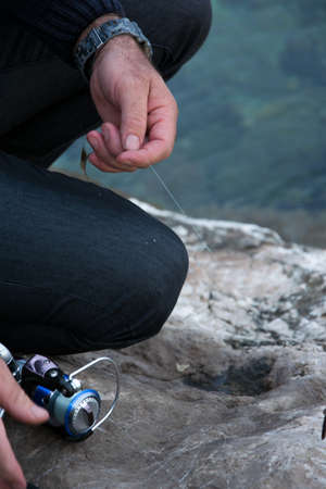 Fisherman holds an angling rod, sport outdoor activity concept
