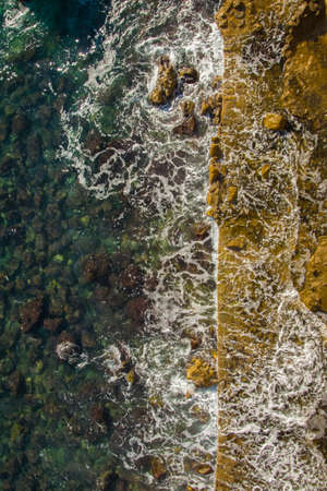 Aerial view of the sea waves washing on the rocky coast of the Adriatic seaの写真素材