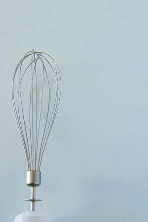 Isolated stainless kitchen utensil - the whisk on white background with space for textの写真素材