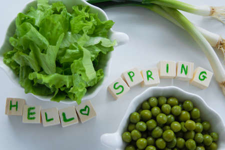 Fresh raw spring vegetables on white background, text  Hello spring