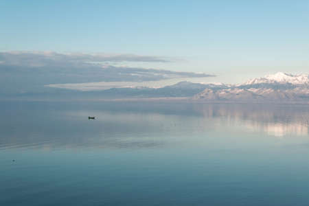 Beautiful scenic landscape  of Shkodra lake, mountains reflection and a little fishing boatの写真素材