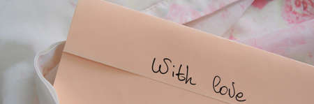 Pastel color envelope on a silky cloth, romantic love conceptの写真素材