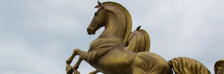 Bronze sculpture of two horses against the skyの写真素材