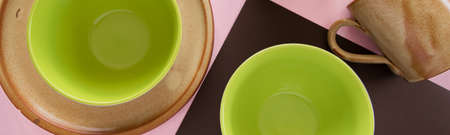 Overhead flat lay view of different clean ceramic tableware on pastel color backgroundの写真素材