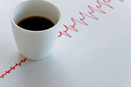 Coffee cup with electrocardiogram lines on white backgroundの写真素材