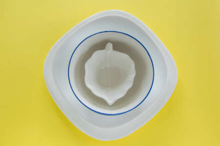 Different porcelain tableware on fresh yellow background