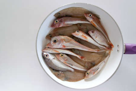 Top view of mixed sea fishes in a pan ready to be cooked