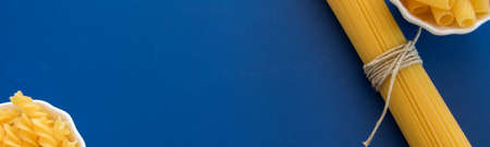 Different  Italian pasta products on blue background, space for menu or text