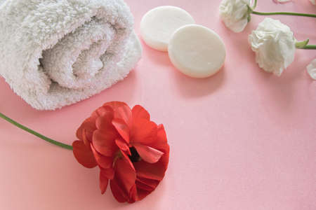 Organic skin care product and delicate flowers on pink background. Healthy cosmetic products ....