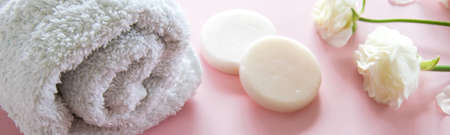 Organic skin care product and delicate flowers on pink background. Healthy cosmetic products . Wellness beauty treatment.の写真素材