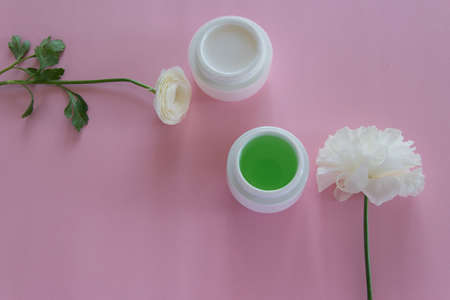 Top view of different hygienic/cosmetic products and flowers on fresh pink background. Wellness beauty treatment. Organic health care productsの写真素材