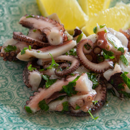 Top view of octopus salad, typical Mediterranean food, on white background with black pepper and sea saltの写真素材