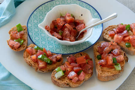 Close up view of tasty tomato Italian appetizers -  bruschetta, on slices of toasted baguette
