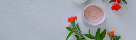 Top view of botanical face powder with blossom pomegranate branch. Herbal cosmeticsの写真素材