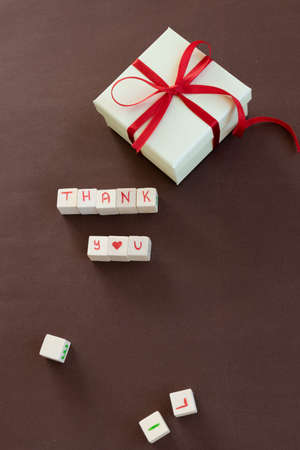 Isolated gift box with "Thank you"  text on brown backgroundの写真素材
