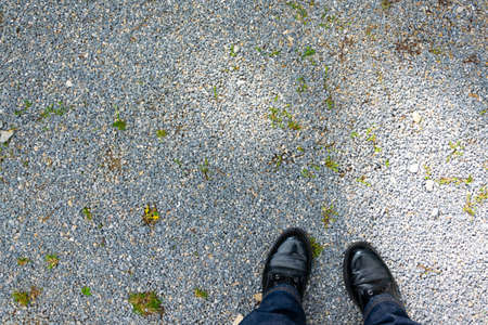 Personal point of view of a person standing on pebbles ground, space for textの写真素材