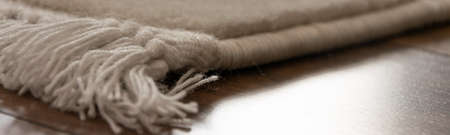 Part of traditional woolen carpet on wooden floor.の写真素材