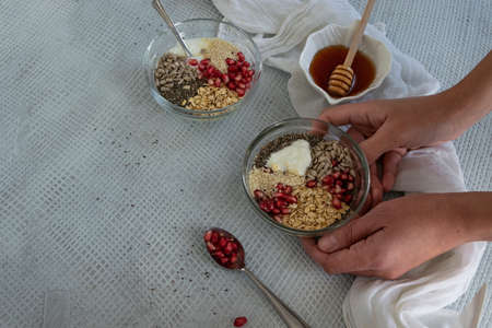 Healthy breakfast mood, muesli with raw pomegranate, sunflower and sesame seeds. Personal point of viewの写真素材