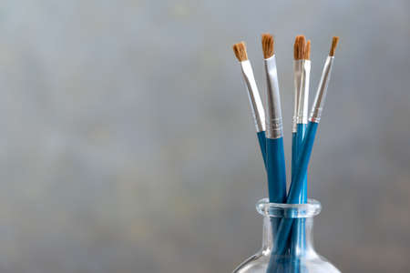 Paint brushes on grey background, artistic craft concept, space for textの写真素材