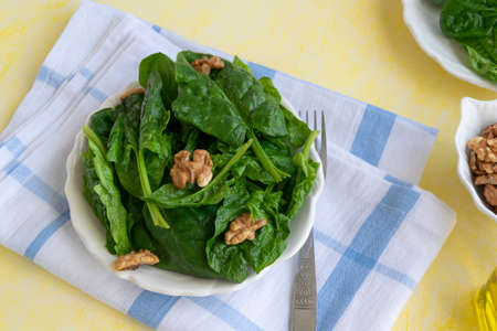 Close up view of raw spinach salad with walnutsの写真素材