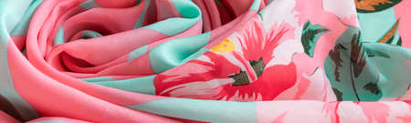 Fresh colorful folded cloth. Crop view of fashioned botanical fabric, pink and blue pastel colors