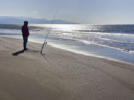 Fishing man on the sea shore