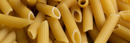 Food background -  dry penne pasta, whole wheat uncooked ingredientの写真素材
