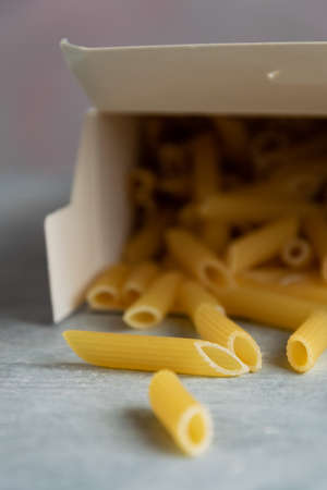Food background -  dry penne pasta, whole wheat uncooked ingredientの写真素材