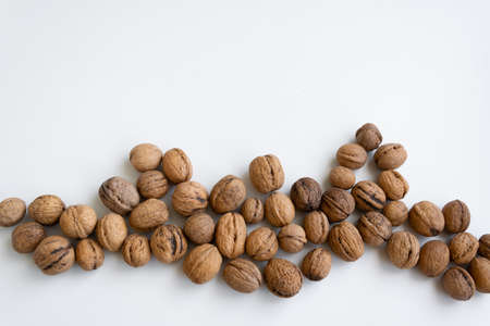 Whole raw walnuts on white background, healthy eating ingredients, vegan and vegetarian food, space...