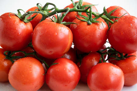 Healthy food ingredient - raw tomatoes on white background, vibrant colours, vitamin food, space for textの写真素材