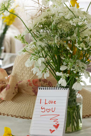 Cosy living interior with wild flowers bouquet and I love you note