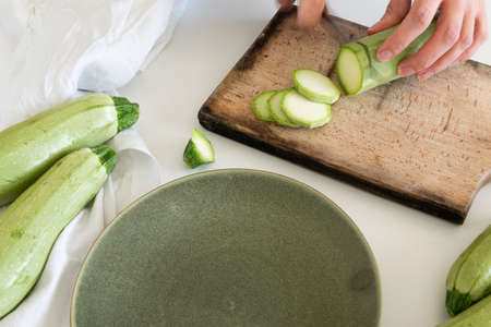 Top view of woman hands preparing fresh ripe garden zucchini. Raw organic vegetables