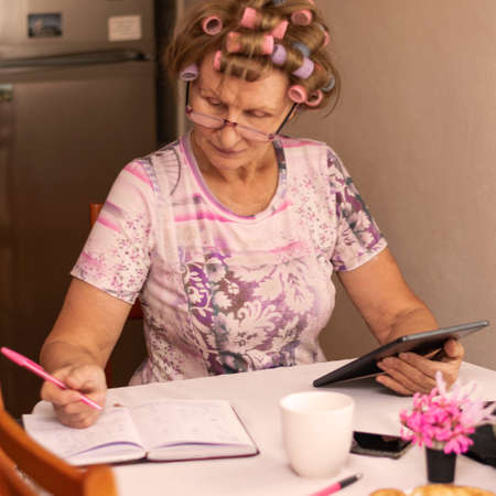 Housewife sitting in kitchen taking care for home budgetの写真素材