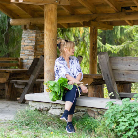 Senior woman holding wildflowers. Outdoor healthy lifestyleの写真素材