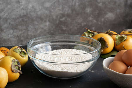 Food ingredients for cooking autumn sweet pie with raw persimmons