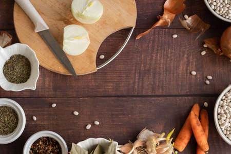 Traditional cuisine - raw beans and seasoning on wooden background