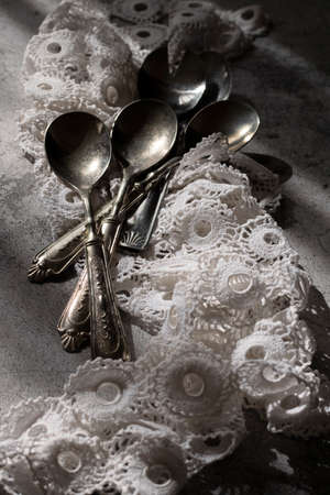 Antique silver spoons with handmade embroidery napkinの写真素材