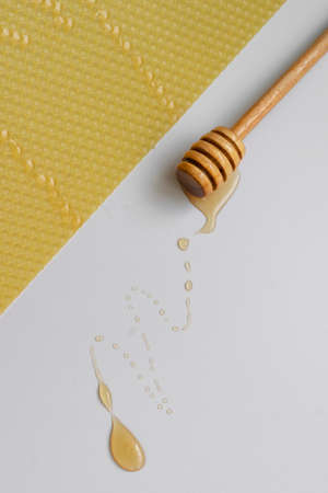 Spoon with raw honey and bee comb on white background, healthy nutrition conceptの写真素材