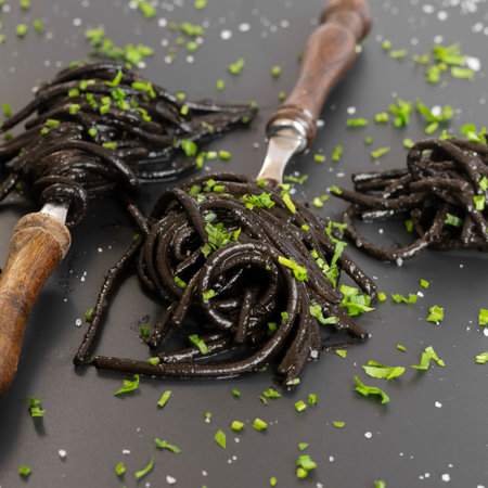 Black spaghetti pasta with Cuttlefish ink. Black seafood pasta on a dark background. Mediterranean delicacy food.の写真素材