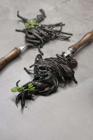 Black spaghetti pasta with Cuttlefish ink. Black seafood pasta on a dark background. Mediterranean delicacy food.の写真素材