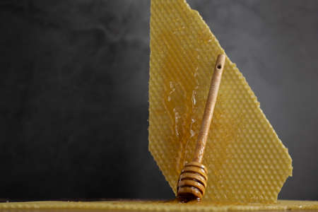 Spoon with raw honey and bee comb on dark background, healthy nutrition conceptの写真素材