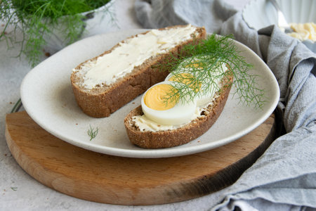 Ingredients for preparing healthy farm breakfast - eggs, whole wheat black bread, goat cream cheese...