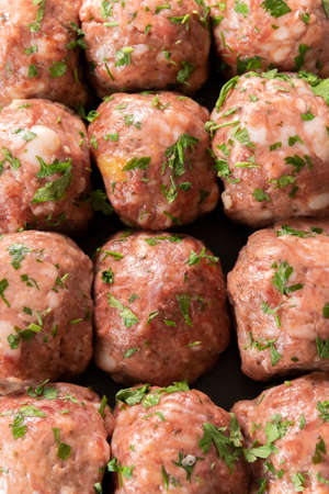 Fresh raw meatballs, minced beef meat on black backgroundの写真素材