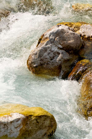 Fast foamy river stream along the tectonic rocks