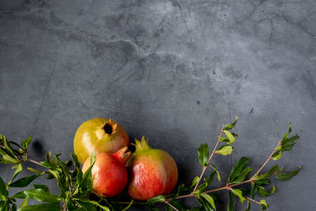 Raw pomegranates on gray background, space for textの写真素材