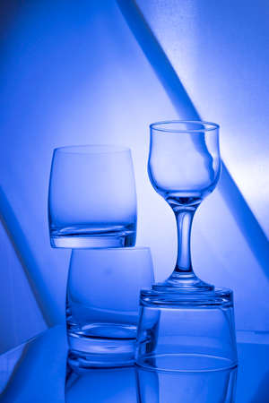 Empty glasses on the table with colorful gradient backlight illuminationの写真素材