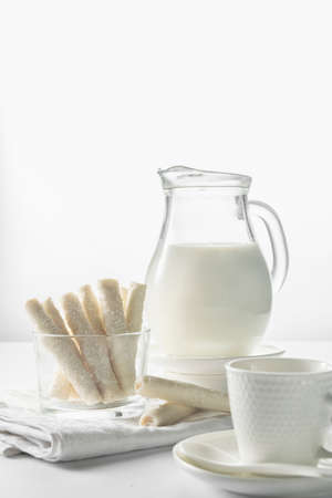Jug with milk and coconut flake sweet waffle rollsの写真素材