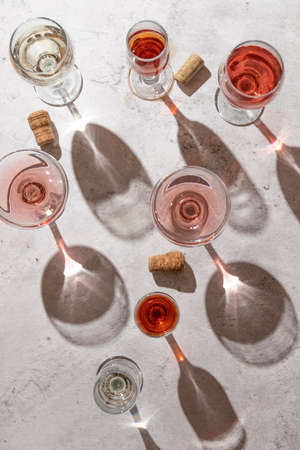 Wine glasses on grey background. Direct sunlight, aesthetic still lifeの写真素材