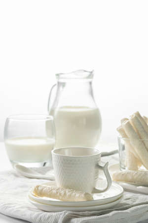 Jug with milk and coconut flake sweet waffle rollsの写真素材