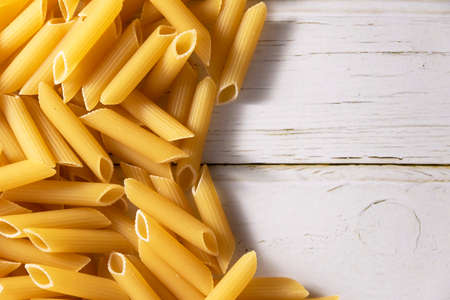 Raw pasta on wooden background, cooking themes, space for text
